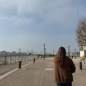 A woman walking along a riverside path exploring her local neighbourhood